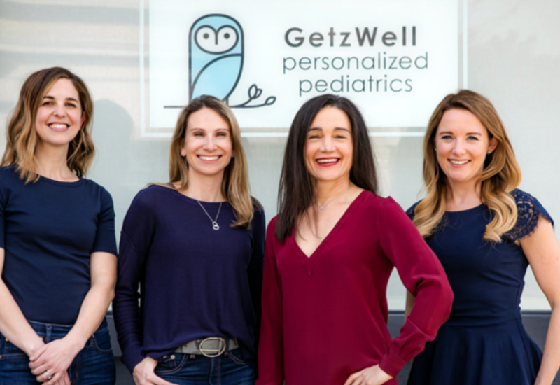 Holistic Pediatricians in San Francisco stand in front of pediatrician office GetzWell with owl sign.