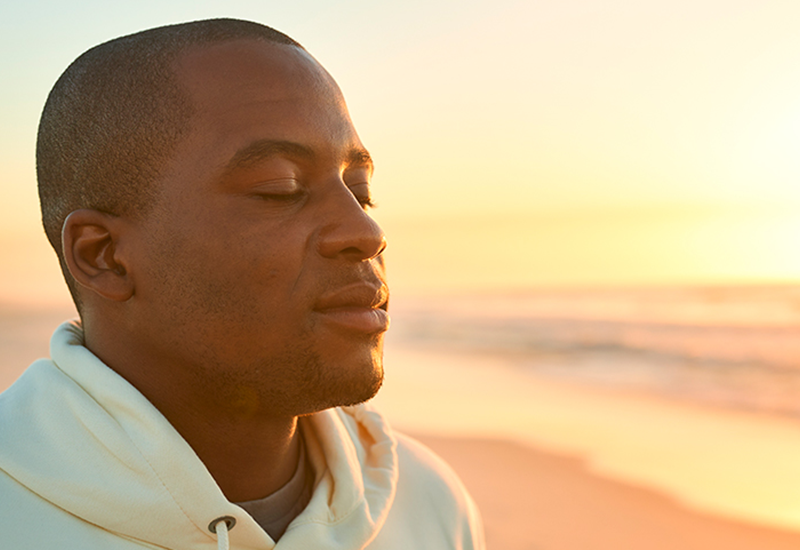 Therapist near me/therapy near me in Mission Viejo, California article main image showing a young man with his eyes closed appearing peaceful with a sunny beach in the background. Celebrating Life Community Health Center has therapists near you in multiple locations in Orange County California, including Mission Viejo, Costa Mesa and Santa Ana, California.